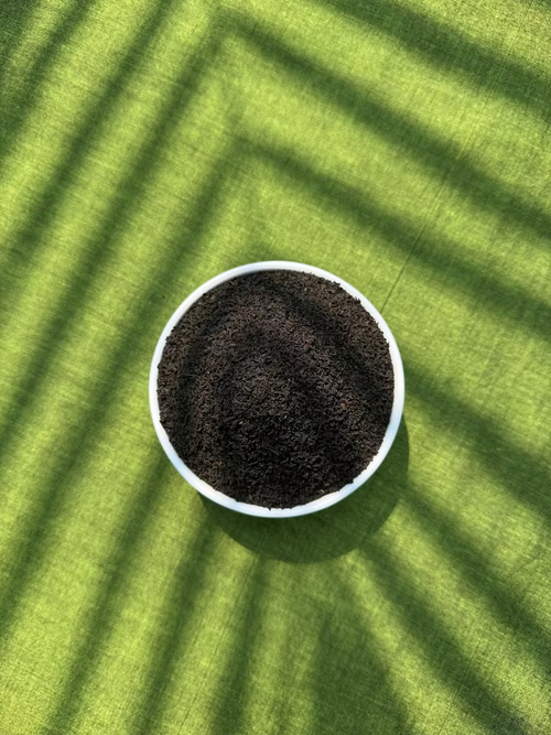 White bowl filled with tea on a green textured surface